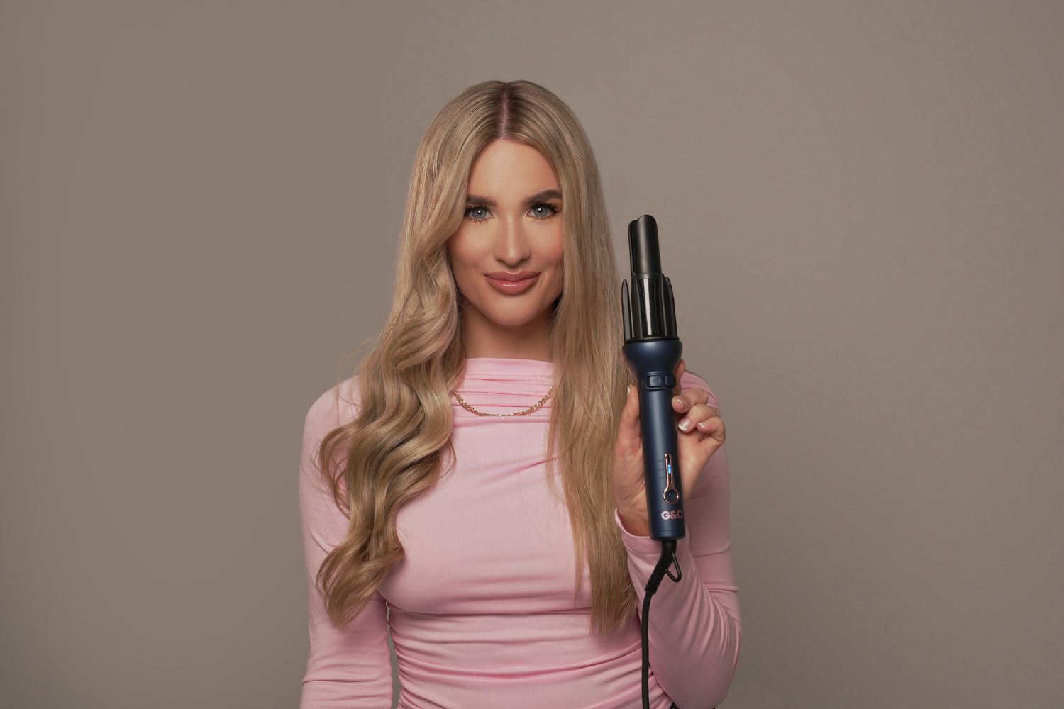 Woman holding a G&C Gold Class Auto Curler – Automatic Hair Curler for Perfect Curls
