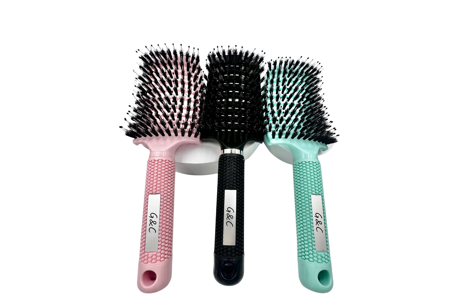 Three gold class g&c hairbrushes with different handles on a white background